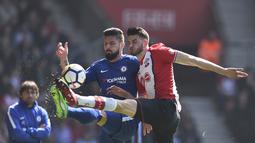 Aksi pemain Chelsea, Olivier Giroud (kiri) berebut bola dengan pemain Southampton, Wesley Hoedt pada lanjutan Premier League di St Mary's Stadium, Southampton, (14/4/2018). Chelsea menang 3-2. (AFP/Glyn Kirk)