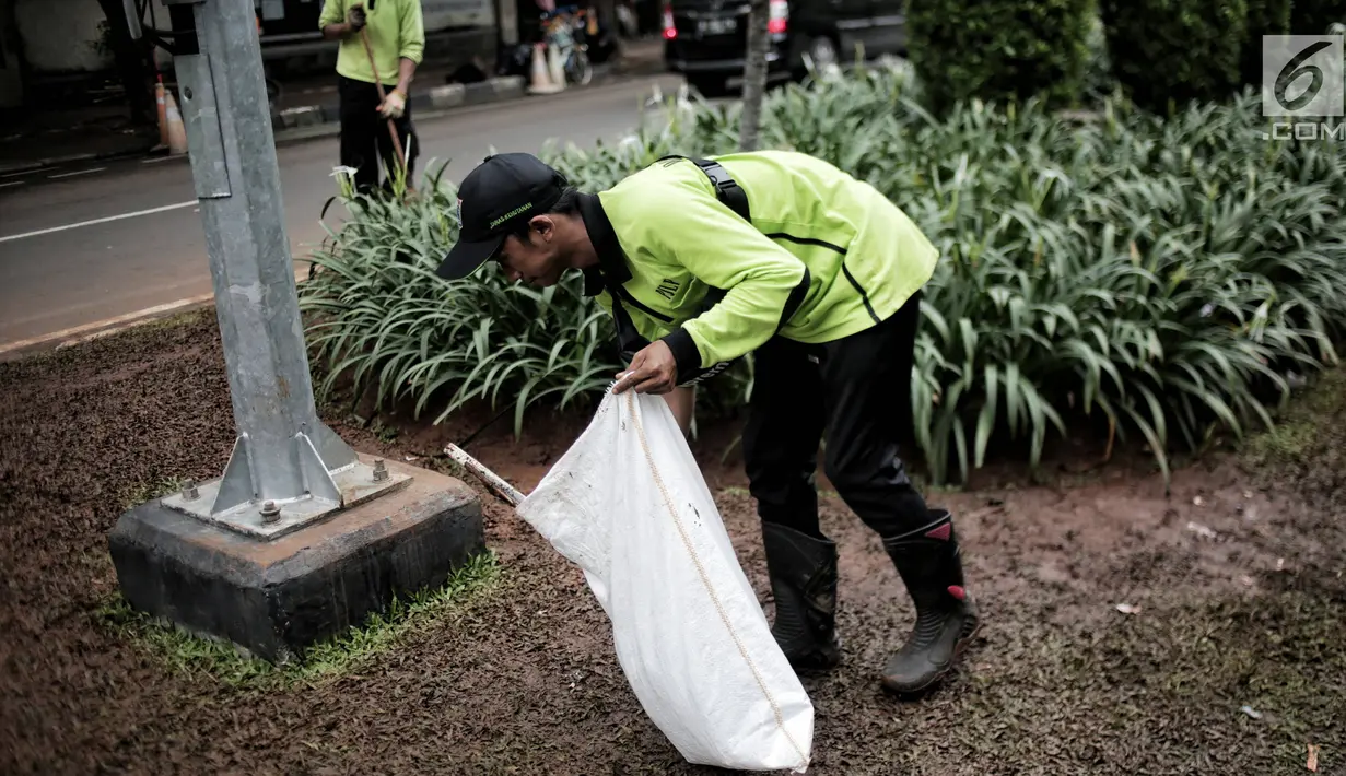 Petugas pertamanan membersihkan tanaman dan rumput yang rusak usai unjuk rasa massa Partai Hanura di depan Gedung KPU, Jakarta, Senin (21/1). Tanaman dan rumput di sekitar Gedung KPU rusak akibat terinjak-injak pengunjuk rasa. (Liputan6.com/Faizal Fanani)
