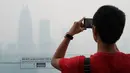 Wisatawan mengambil gambar dari Kuala Lumpur Tower saat kabut asap pekat menyelimuti Kuala Lumpur, Malaysia, Jumat (13/9/2019). Kabut asap membuat kualitas udara memburuk. (AP Photo/Vincent Thian)