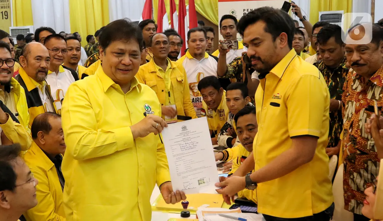 Ketua Umum Golkar Airlangga Hartarto menyerahkan berkas pendaftaran bakal calon ketua umum (caketum) Partai Golkar kepada Ketua Komite Pemilihan Maman Abdulrahman (kanan) di DPP Partai Golkar, Jakarta, Senin (2/12/2019). (Liputan6.com/Johan Tallo)