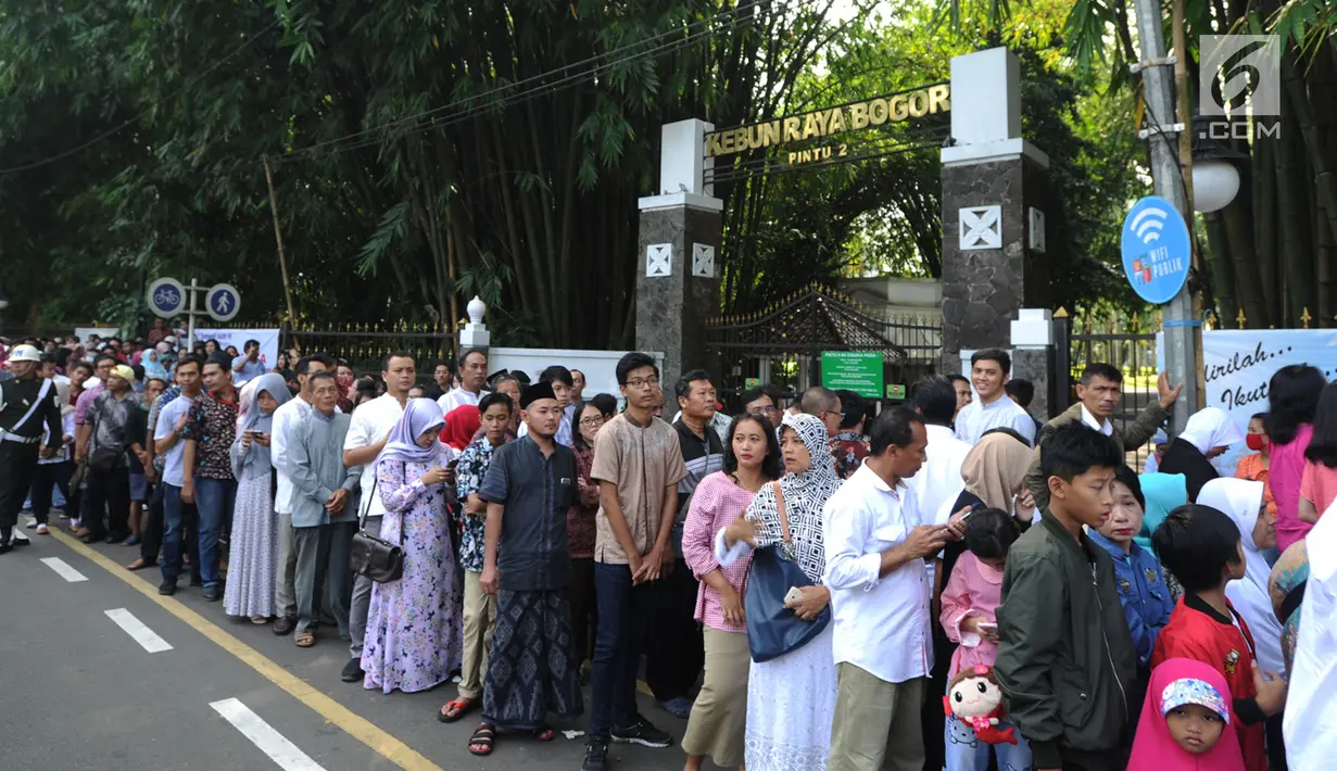 Warga antre masuk ke dalam Istana Bogor saat kegiatan open house Presiden Joko Widodo di Jalan Ir.H.Djuanda, Bogor (15/6). Ribuan warga antre untuk bersalaman mengucapkan selamat Idul Fitri  1439 H. (Merdeka.com/Arie Basuki)