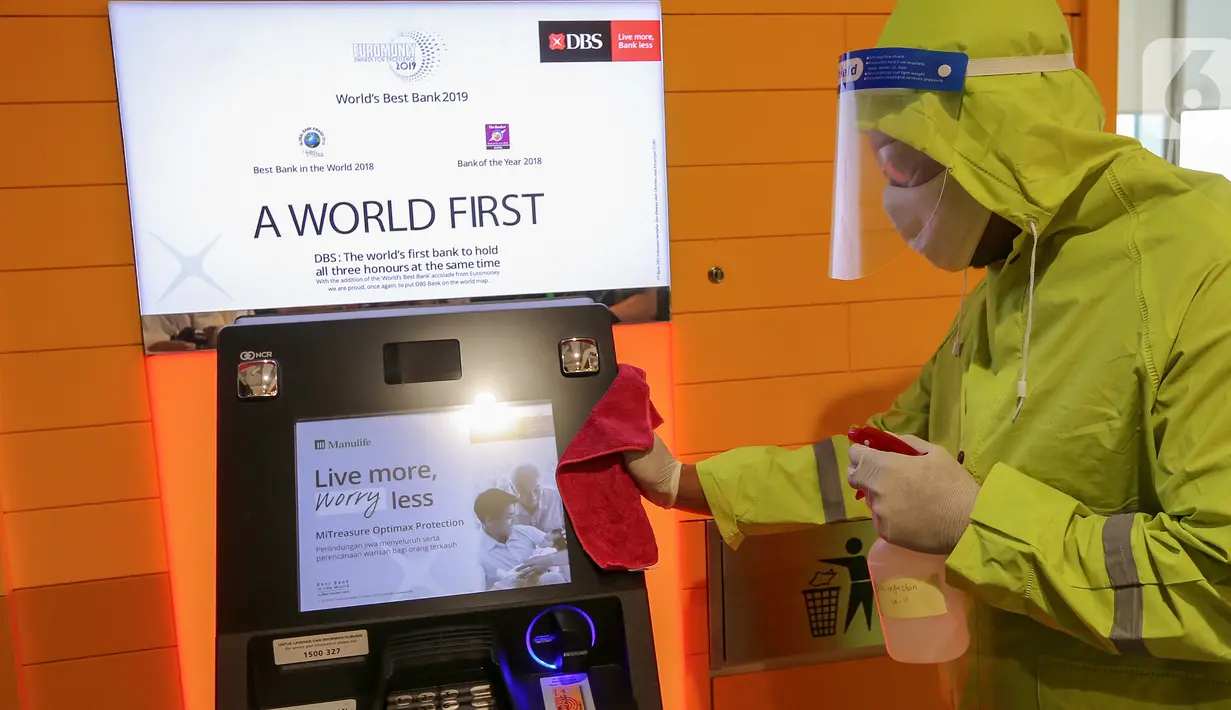 Petugas membersihkan mesin ATM di kantor DBS Tower, Jakarta, Selasa (30/6/2020). Bank DBS Indonesia menerapkan protokol kesehatan dengan penyemprotan cairan desinfektan dan melakukan pelapisan antimicrobial di area kantor untuk mencegah penyebaran virus Covid-19. (Liputan6.com/Fery Pradolo)