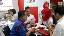 Karyawan Bank DKI menjelaskan aplikasi JakOne Mobile kepada pengunjung Pekan Raya Jakarta di Jakarta (23/5). JakOne Mobile dapat digunakan sebagai alat pembayaran pada merchant yang sudah bekerjasama. (Liputan6.com/Pool/Budi)