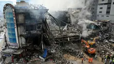 Petugas penyelamat mencari korban di antara puing-puing setelah kebakaran besar di sebuah pusat perbelanjaan di Karachi pada Senin 19 Januari 2026. Tim pencari dan penyelamat di Karachi, Pakistan, masih berjuang melakukan pencarian korban di reruntuhan sebuah gedung pusat perbelanjaan. (Asif HASSAN/AFP)