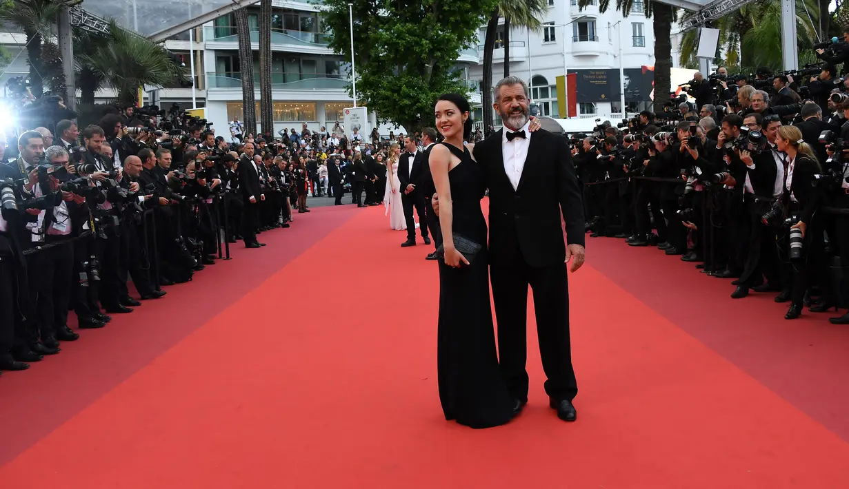 Aktor senior Mel Gibson didampingi pacar barunya, Rosalind Ross tiba untuk menghadiri acara penutupan Festival Film Cannes ke-69 di Prancis, 22 Mei 2016. Keduanya tampak kompak berdandan klasik dan elegan dengan tuxedo dan gaun hitamnya (AFP PHOTO)
