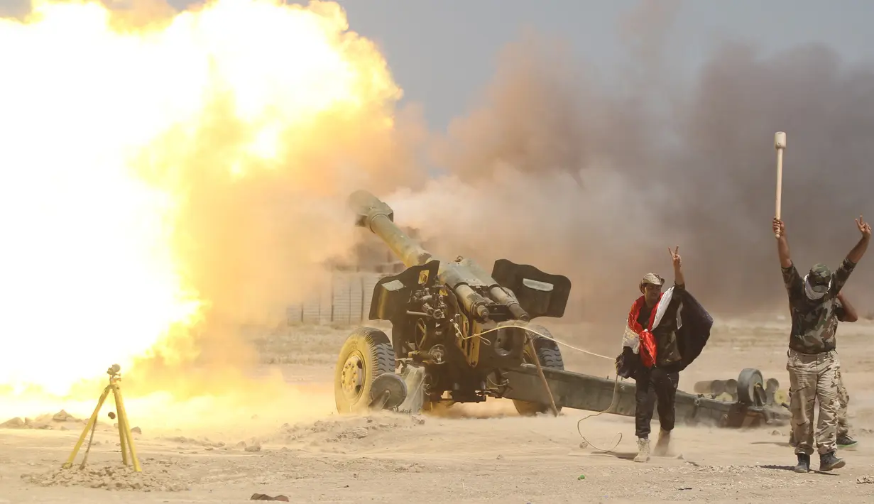 Pejuang Syiah dan tentara Irak menembakkan senjata ke arah kelompok militan ISIS di dekat Falluja , Irak , 29 Mei 2016. Berbagai kelompok seperti Syiah dan Peshmerga Kurdi  saling membantu untuk menghancurkan ISIS. (REUTERS / Alaa Al - Marjani)