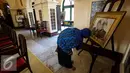 Pengunjung melihat keterangan foto yang dipajang di Istana Siak Sri Indrapura, Riau, Kamis (21/7). Istana Siak menyimpan banyak peninggalan sejarah Kerajaan Siak yang menarik perhatian pengunjung. (Liputan6.com/Faizal Fanani)