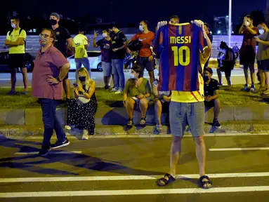 Suporter melakukan protes di depan kantor Barcelona, Selasa (25/8/2020). Aksi tersebut merupakan respon fans atas kabar Lionel Messi yang akan meninggalkan Camp Nou pada musim panas ini. (AFP/Pau Barrena)