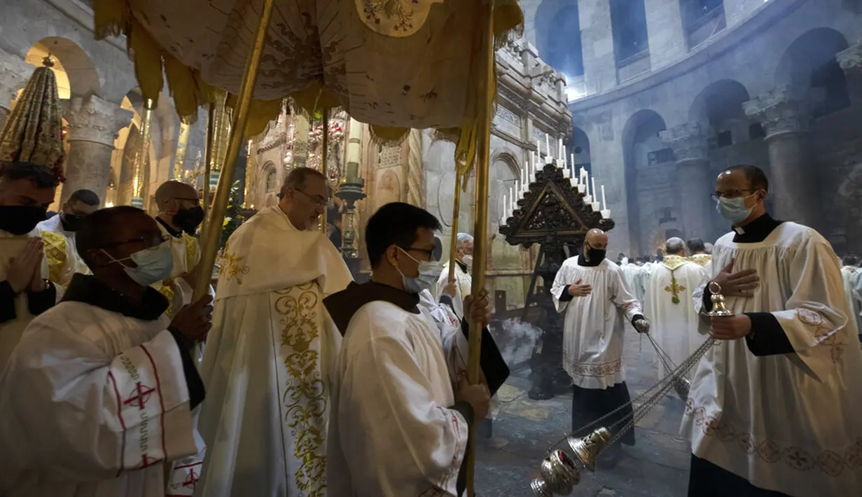 Patriark Latin Yerusalem Pierbattista Pizzaballa (kiri tengah) berjalan di bawah kanopi mengelilingi Makam Kudus saat misa Kamis Putih di Kota Tua Yerusalem, Kamis (1/4/2021). Kamis Putih adalah hari Kamis sebelum Paskah. (AP Photo/Maya Alleruzzo)