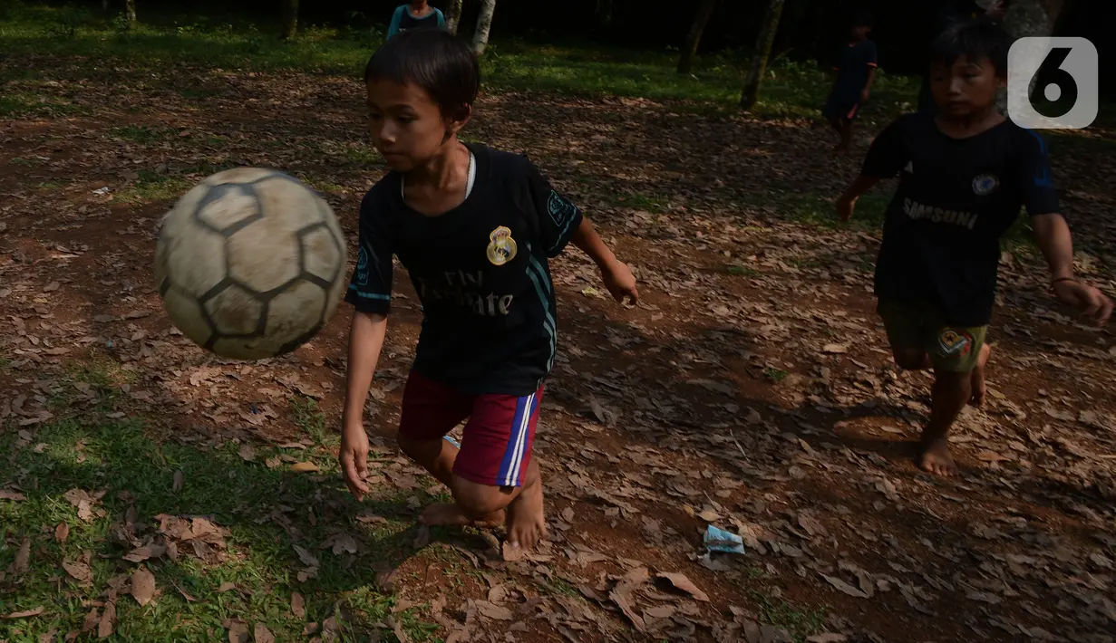 Sejumlah anak bermain sepak bola di lahan kebun Karet desa Cibodas, Bogor, Jawa Barat Sabtu (4/9/2021). Meskipun lapangan sepak bola seadanya berada di lahan Kebun karet, anak-anak bermain dengan semangat berlatih dan sering ikut turnamen antar kampung. (merdeka.com/Imam Buhori)
