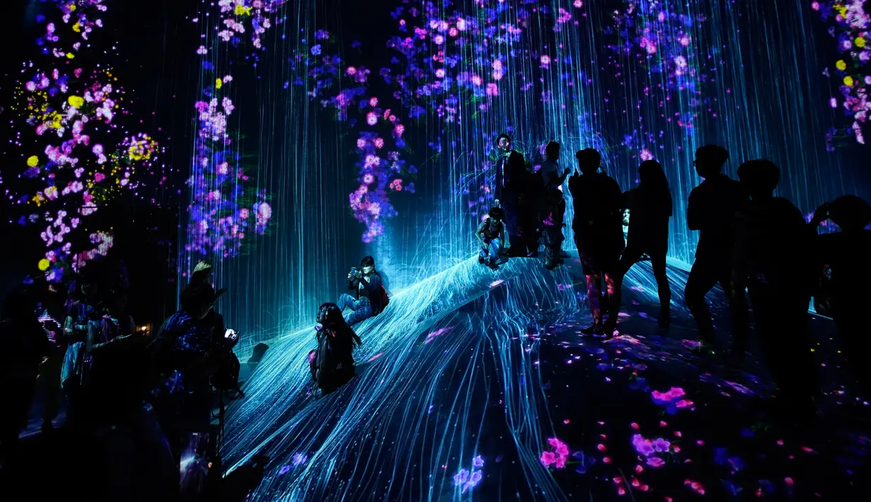 Pengunjung menyaksikan instalasi digital yang menampilkan proyeksi air terjun dan bunga di Museum Seni Digital Mori Building, Tokyo, 21 Juni 2018. Museum seluas 10.000 meter persegi ini banyak menampilkan seni digital mengagumkan. (AP/Shuji Kajiyama)