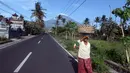 Warga berjalan di sekitar Amed, Kab Karangasem, Bali, Selasa, (26/9). Pusat Vulkanologi dan Mitigasi Bencana Geologis (PVMBG) menaikkan status Gunung Agung dari level III Siaga menjadi level IV Awas, Jumat (22/9) lalu. (AP Photo / Firdia Lisnawati)