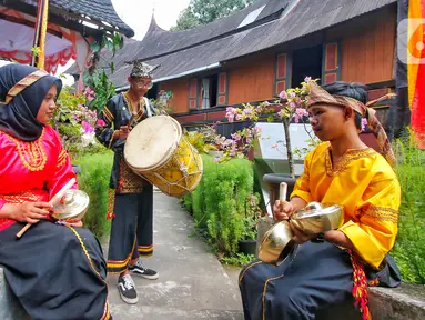 Para pemuda memainkan alat musik kesenian tradisional di Desa Wisata Kampuang Minang Nagari Sumpu, Kabupaten Tanah Datar, Provinsi Sumatera Barat, Kamis (22/6/2023). (Liputan6/Angga Yuniar)