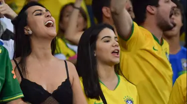 Dua fans wanita bersorak menunggu pertandingan antara Brasil melawan Argentina pada semifinal Copa America 2019 di Stadion Mineirao, Belo Horizonte, Brasil (2/7/2019). Di pertandingan ini Brasil menang 2-0 atas Argentina berkat gol striker Gabriel Jesus dan Roberto Firmino. (AFP Photo/Luis Acosta)