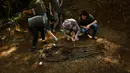 Arkeolog memasang garis saat memeriksa kuburan yang diyakini berisi dua tahanan republik yang tewas selama Perang Saudara Spanyol di Leranoz, Pyrenees, sekitar 30 km (21,78 mil) dari Pamplona, Spanyol utara, Selasa (22/5). (AP Photo/Alvaro Barrientos)