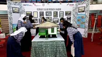 Miniatur rumah Dahor beserta foto sejarah yang ditampilkan dalam pameran Pekan Kebudayaan Daerah Kaltim 2022. (Liputan6.com/Istimewa)