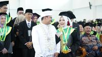 Momen unik pasutri di Kudus berpakaian pengantin saat mengikuti wisuda. (Liputan6.com/Arief Pramono)