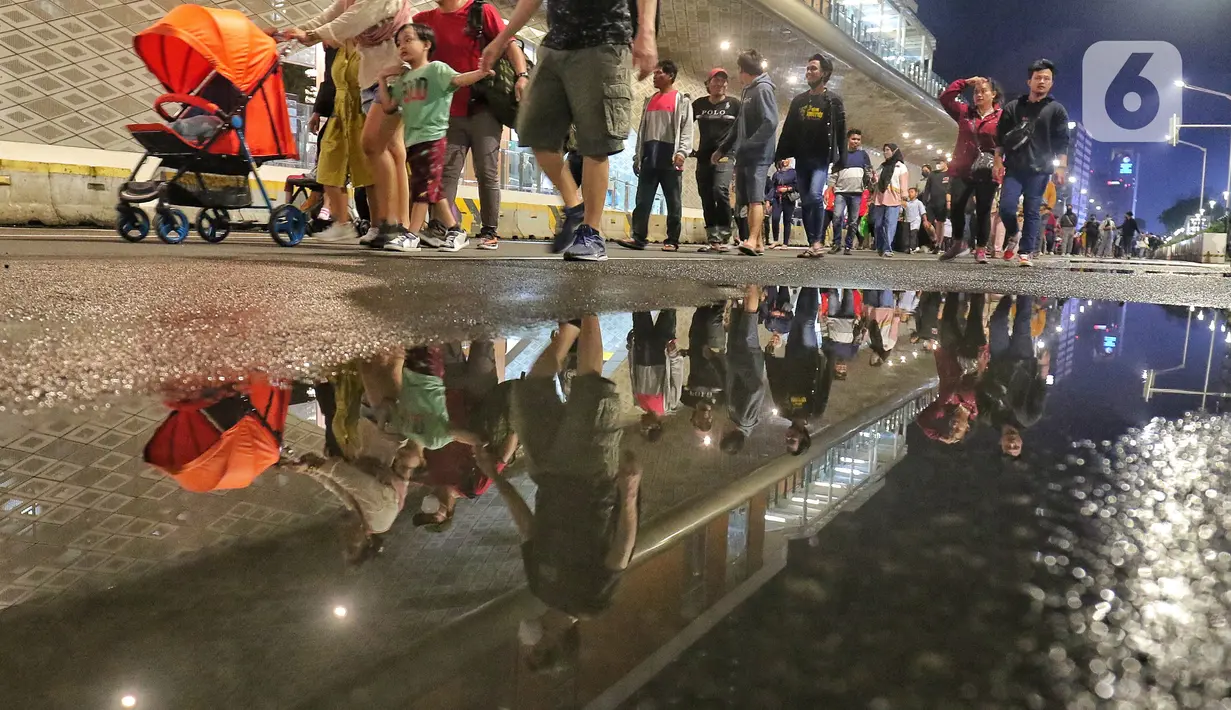 Warga memadati Car Free Night (CFN) pada malam pergantian tahun baru 2023 di kawasan Bundaran Hotel Indonesia, Jakarta, Sabtu (31/12/2022). Banyak warga yang berkumpul merayakan pergantian tahun baru sambil berswafoto, menikmati kuliner, berjalan hingga bersepeda santai. (Liputan6.com/Angga Yuniar)