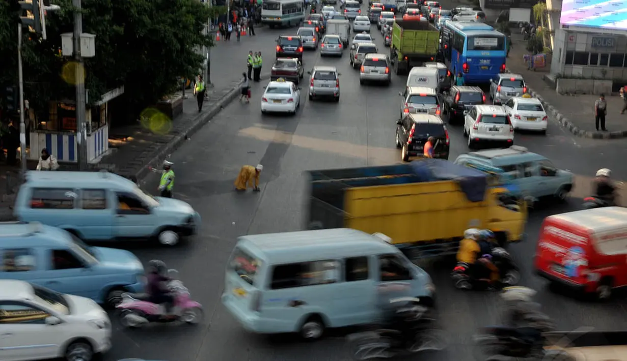 Beberapa pejalan kaki menyeberang jalan di kawasan Slipi, Jakarta, tidak menggunakan jembatan penyeberangan, (26/9/14). (Liputan6.com/Johan Tallo)