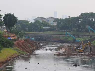 Alat berat excavator mengeruk tanah dan lumpur pada proyek pengendalian banjir sodetan Ciliwung di  Sungai Kanal Banjir Timur, Cipinang, Jakarta, Jumat (26/5/2023). (merdeka.com/imam buhori)