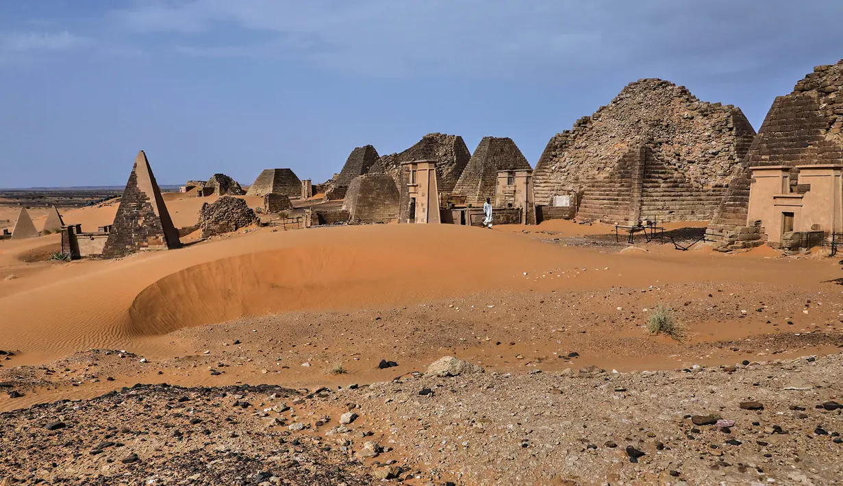 Seorang pengunjung berjalan diantara piramida Meroe di situs arkeologi Meroe di Bejrawiya, Sudan, Sabtu, 1 Agustus 2026. (Foto AP/Mohnd Blal)
