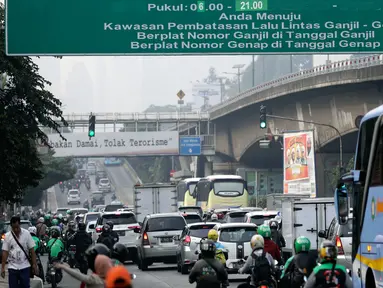Kendaraan melintas di bawah papan informasi sistem ganjil genap di Jalan S Parman, Jakarta, Rabu (1/8). Pemprov DKI hari ini resmi memberlakukan sistem ganjil genap dengan memberikan sanksi tilang bagi pengendara yang melanggar. (Liputan6.com/Johan Tallo)
