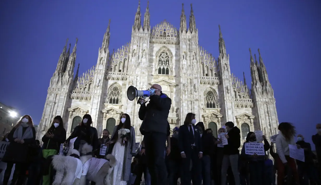 Pemilik toko dan pekerja memprotes langkah-langkah pembatasan pemerintah untuk mengekang penyebaran COVID-19, di depan katedral gothic Milan, Italia, 12 November 2020. Beban kasus baru Infeksi COVID-19 sehari-hari Italia dikonfirmasi naik jauh lebih tinggi pada hari Kamis. (AP Photo/Luca Bruno)