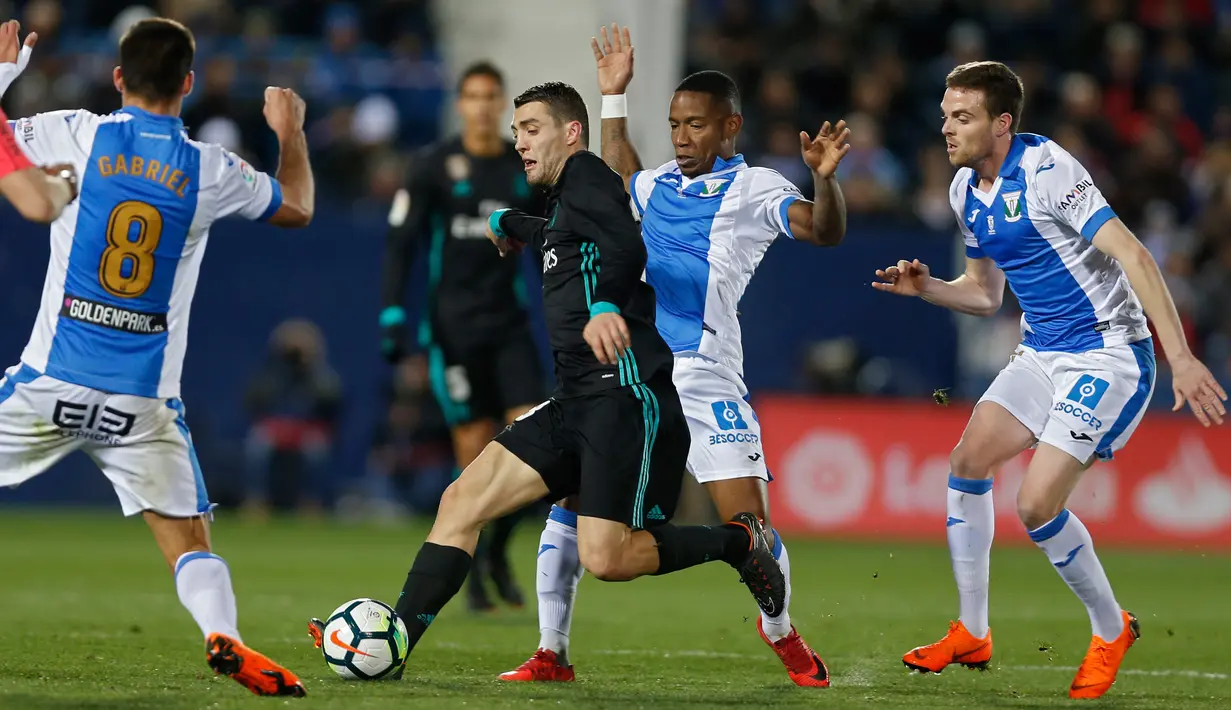 Pemain Real Madrid, Mateo Kovacic mengendalikan bola dengan kawalan pemain Leganes pada partai tunda pekan ke-16 La Liga Spanyol di Estadio Municipal de Butarque, Rabu (21/2). Madrid menang 3-1 atas Leganes meski sempat ketinggalan. (AP/Francisco Seco)