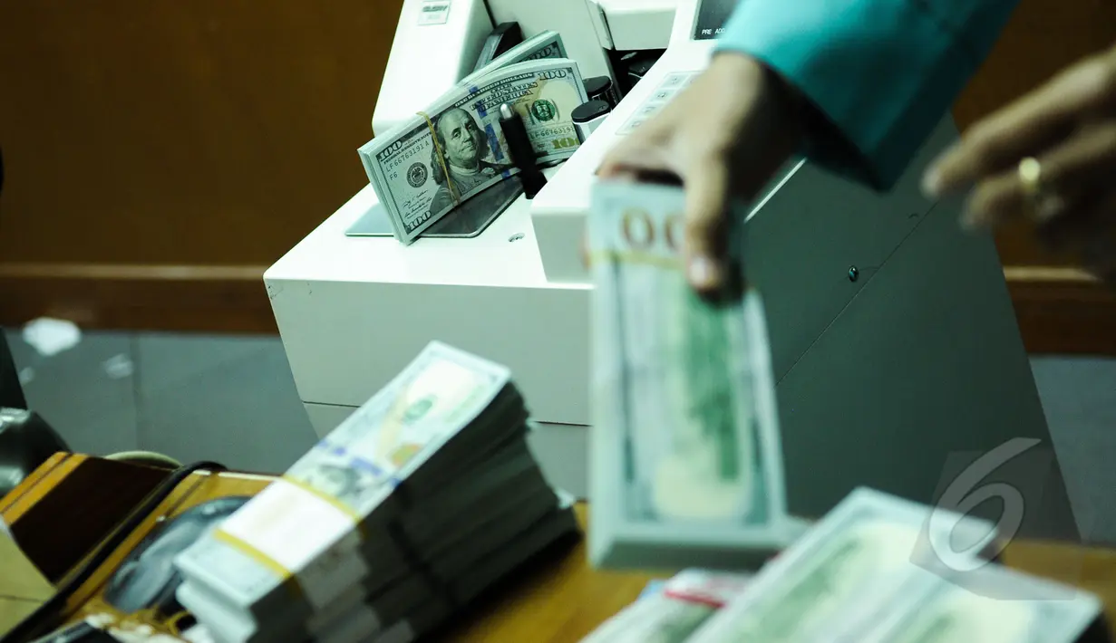 Petugas menghitung mata uang AS di penukaran valas Ayu Masagung, Jakarta, Senin (9/3/2015). Pada awal perdagangan rupiah dibuka pada level 12.994 atau melemah 18 poin dibanding penutupan akhir pekan lalu di posisi 12.976. (Liputan6.com/Faizal Fanani)