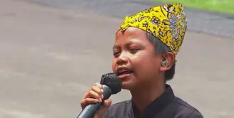 Farel Prayoga bernyanyi di hadapan Presiden Jokowi beserta para menteri dengan mengenakan beskap berwarna hitam dan celana panjang. (Tangkapan layar YouTube Sekretariat Presiden)
