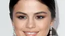 Hari itu Selena tampil mengenakan gaun panjang berwarna merah. Makeup yang diaplikasikan di wajahnya ditonjolkan pada bagian mata yang terlihat smokey dan tampak seksi. Ditambah gaya rambut ponytail membuat Selena terlihat fresh. (AFP/Bintang.com)