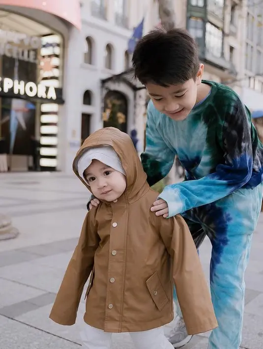 Rayyanza juga menggemaskan mengenakan jaket leather coklat dipadukan hoodie dan celana tracksuit abu-abunya. [@raffinagita1717]