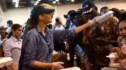 Ibu negara AS, Melania Trump membagikan makanan kepada korban Badai Harvey di NRG Center di Houston (2/9). Kerusakan yang ditimbulkan Badai Harvey dapat telan biaya US$ 160 miliar atau sekitar Rp 2.135 triliun. (AFP Photo/Nicholas Kamm)