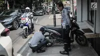 Petugas Dishub DKI Jakarta merazia  kendaraan roda dua dengan mencopot pentil yang terparkir di trotoar di kawasan Cipete Raya, Jakarta, Selasa (13/8/2019). Razia tersebut dilakukan Dishub untuk mengembalikan fungsi trotoar