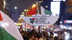 Seorang pengunjuk rasa memegang plakat penghormatan kepada Global Sumud Flotiila saat berunjuk rasa dalam solidaritas kepada warga Palestina dan mengutuk pencegatan armada oleh tentara Israel, di Istanbul, Turki pada 2 Oktober 2025. (KEMAL ASLAN/AFP)