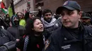 Seorang pengunjuk rasa pro-Palestina berteriak kepada seorang petugas NYPD saat unjuk rasa "All out for Palestine" di luar Universitas Columbia di New York pada 2 Februari 2024. (Yuki IWAMURA/AFP)