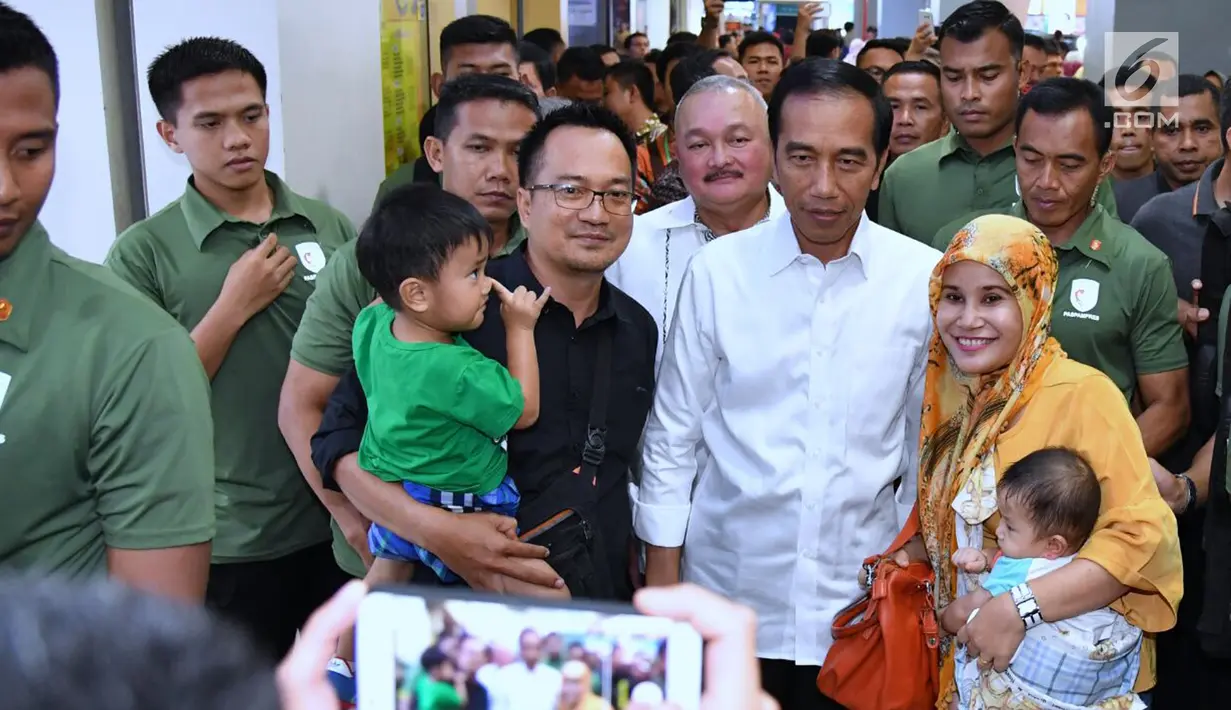 Warga berswafoto bersama Presiden Joko Widodo atau Jokowi saat menyambangi Palembang Square, Palembang (21/1). Banyak warga terkejut mengetahui kedatangan Presiden di sebuah mal Palembang tersebut. (Liputan6.com/Pool/Biro Setpres)
