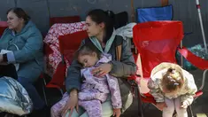 Pengungsi Ukraina menunggu untuk memasuki Amerika Serikat di Pelabuhan Masuk San Ysidro perbatasan AS-Meksiko, di Tijuana, Meksiko, pada 4 April 2022. Ratusan warga Ukraina menunggu di sebuah perkemahan di Tijuana, selatan San Diego, berharap untuk mencari suaka AS. (SANDY HUFFAKER/AFP)