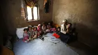 Seorang warga Yaman beserta anak-anaknya di desa Hazyaz, pinggir kota Sana'a, Yaman. PBB melaporkan bahwa Yaman akan segera dilanda bencana kelaparan terbesar dunia jika masyarakat internasional tidak segera memberikan bantuan humaniter (AP)