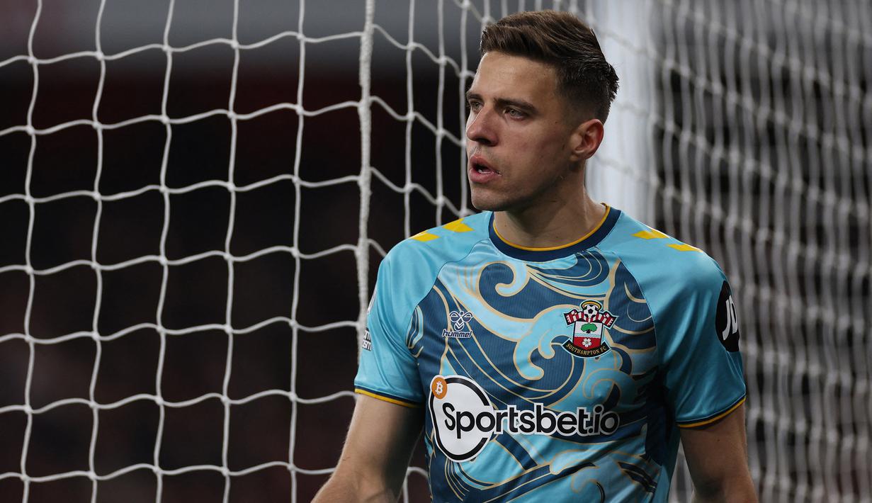 Bek Southampton, Jan Bednarek berjalan meninggalkan lapangan usai tak diijinkan melanjutkan pertandinagn oleh tim medis saat menghadapi Arsenal pada laga Liga Inggris 2022/2023 di Emirates Stadium, London (21/4/2023). (AFP/Adrian Dennis)