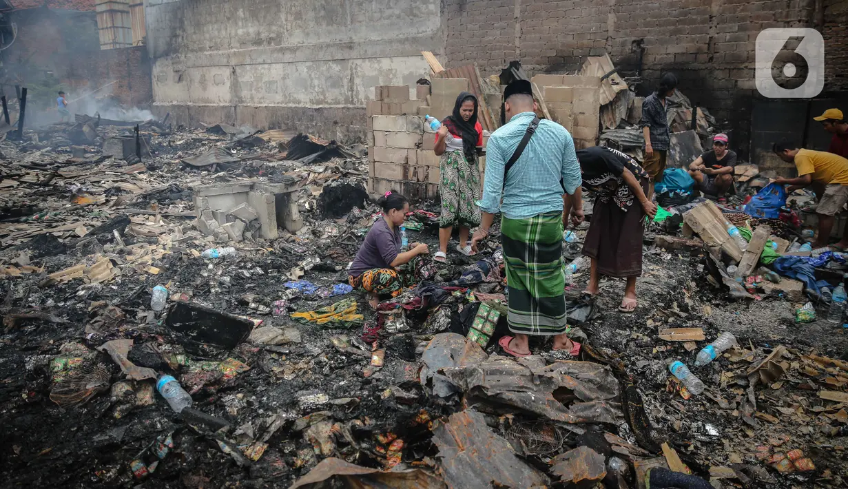 Warga mencari barang berharga di sekitar puing-puing bangunan tempat tinggal mereka yang terbakar di Jalan Tanah Abang 5 RT 003,004/RW 003, Petojo Selatan, Gambir, Jakarta Pusat, Senin (27/2/2023). Saat terdapat lima titik lokasi pengungsian sementara yang diperuntukkan bagi warga terdampak, yakni di Kantor Pos RW 07, Pos Amphibi RW 07, Kantor Kelurahan Petojo Selatan, Kantor Kelurahan Gambir, dan tenda di lokasi kebakaran.  (Liputan6.com/Faizal Fanani)