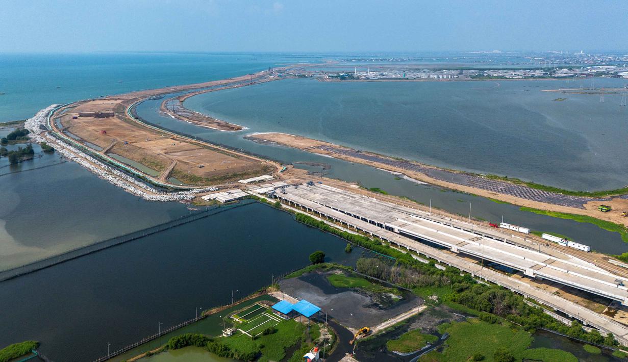 Sebagai informasi, proyek senilai Rp10,9 triliun ini merupakan salah satu solusi jangka panjang untuk permasalahan banjir di kawasan pesisir Semarang-Demak. Tamopak foto udara menunjukkan pembangunan Jalan Tol Laut Semarang-Demak, sebuah mega-proyek nasional yang dirancang untuk mengatasi banjir pasang surut air laut yang sering terjadi di sepanjang pantai utara, di Semarang, Jawa Tengah, pada Minggu 19 April 2026. (DEVI RAHMAN/AFP)