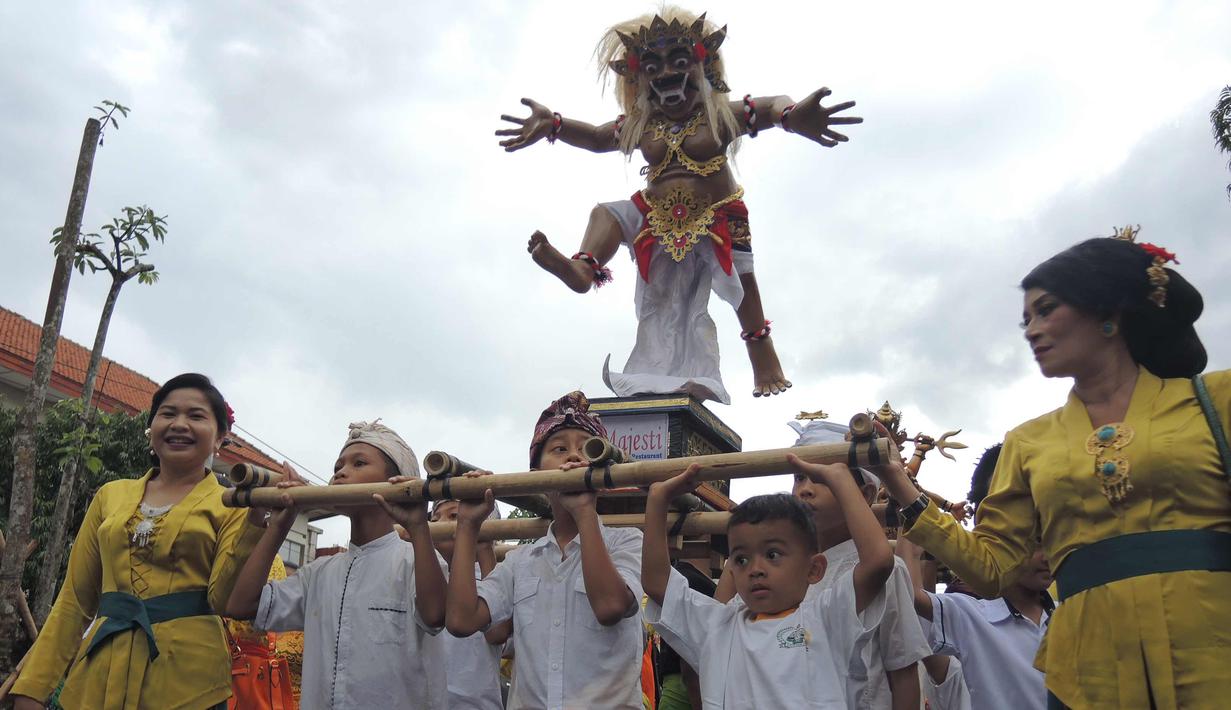 Anak-anak mengarak Ogoh-Ogoh selama atraksi Karnaval Seni Budaya Lintas Agama di kawasan Jalan Pemuda  Semarang, Minggu (25/3). Lima ogoh-ogoh yang didatangkan dari Bali ikut memeriahkan acara ini. (Liputan6.com/Gholib)