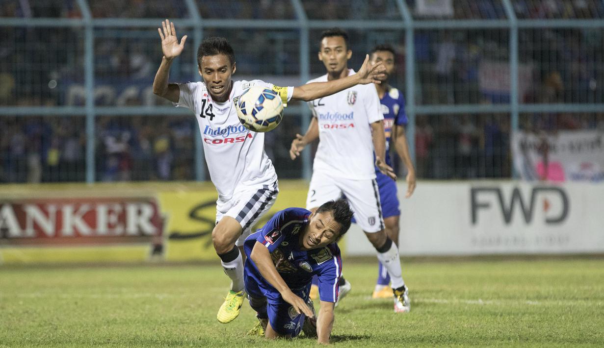 Pemain Arema Cronus, Samsul Arif terjatuh saat duel dengan pemain Bali United, Fadil Sausu pada laga perempat final Piala Presiden di Stadion Kanjuruhan, Malang, Sabtu (19/9/2015). (Bola.com/Vitalis Yogi Trisna)