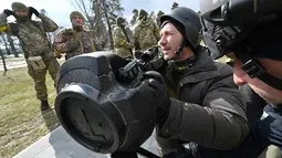 Anggota Pasukan Pertahanan Teritorial Ukraina memeriksa persenjataan baru, termasuk sistem anti-tank NLAW dan peluncur granat anti-tank portabel lainnya, di tengah invasi Rusia yang sedang berlangsung ke Ukraina di Kiev (9/3/2022). (AFP/Genya Savilov)