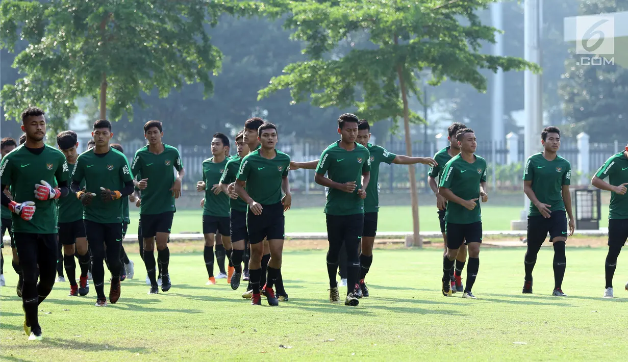 Pemain Timnas Indonesia U-19 berlari kecil jelang latihan di Lapangan B Kompleks GBK, Jakarta, Selasa (18/9). Latihan ini persiapan  PSSI Anniversary Cup U-19 dan Piala AFC U19. (Liputan6.com/Helmi Fithriansyah)