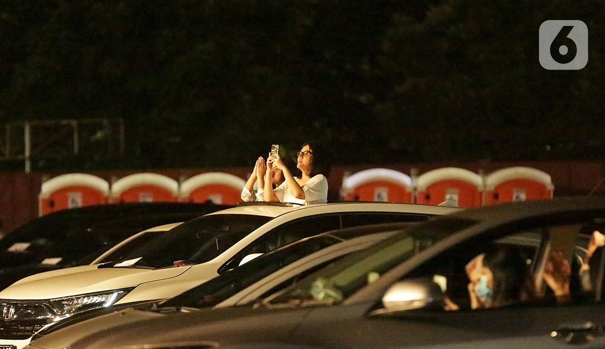 Dua wanita mengabadikan penampilan Kahitna dalam konser New Live Experience 2020 di Parkir Barat JIExpo Kemayoran, Jakarta, Sabtu (29/8/2020). Acara musik dengan konsep drive in concert menjadi alternatif dan solusi hiburan masyarakat saat situasi pandemi. (Fimela.com/Bambang E.Ros)