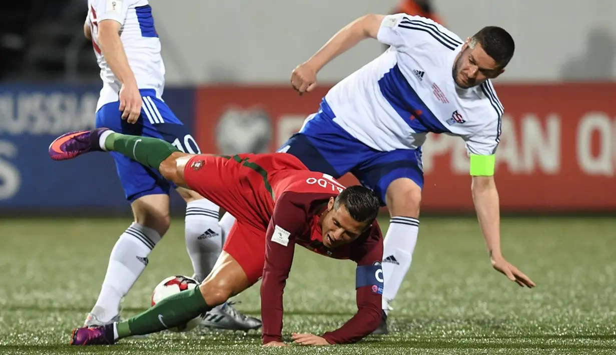 Cristiano Ronaldo dilanggar pemain Kepulauan Faroe pada laga Grup B Kualifikasi Piala Dunia 2018 zona Eropa di Torsvollur Stadium, Selasa (11/10/2016) dini hari WIB. (AFP/Francisco Leong)