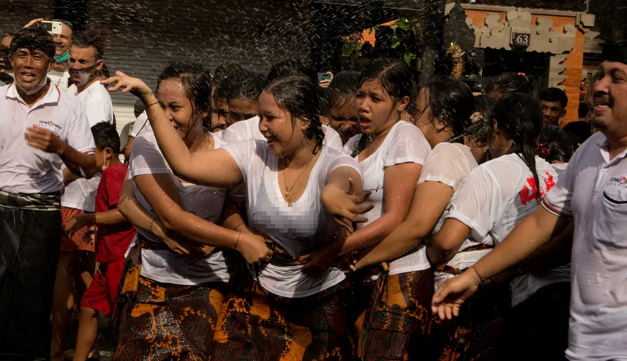 Peserta perempuan mempersiapkan kelompok mereka selama tradisi Omed-omedan (cium-ciuman) di Denpasar, Bali, Jumat (4/3/2022). "Omed-omedan" merupakan ritual tradisi khas muda-mudi yang dilaksanakan sehari setelah Hari Raya Nyepi. (AP Photo/Firdia Lisnawati)