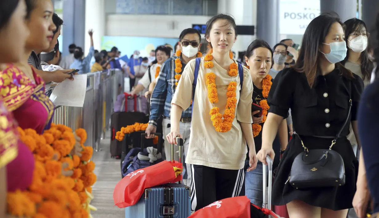 <p>Wisatawan mancanegara (wisman) asal China tiba di bandara internasional Ngurah Rai di Bali, Minggu (22/1/2023). Penerbangan langsung turis China mendarat di pulau Bali untuk pertama kalinya pada hari Minggu dalam hampir tiga tahun setelah ditutupnya rute penerbangan lantaran kebijakan nol Covid-19. (AP Photo/Firdia Lisnawati)</p>